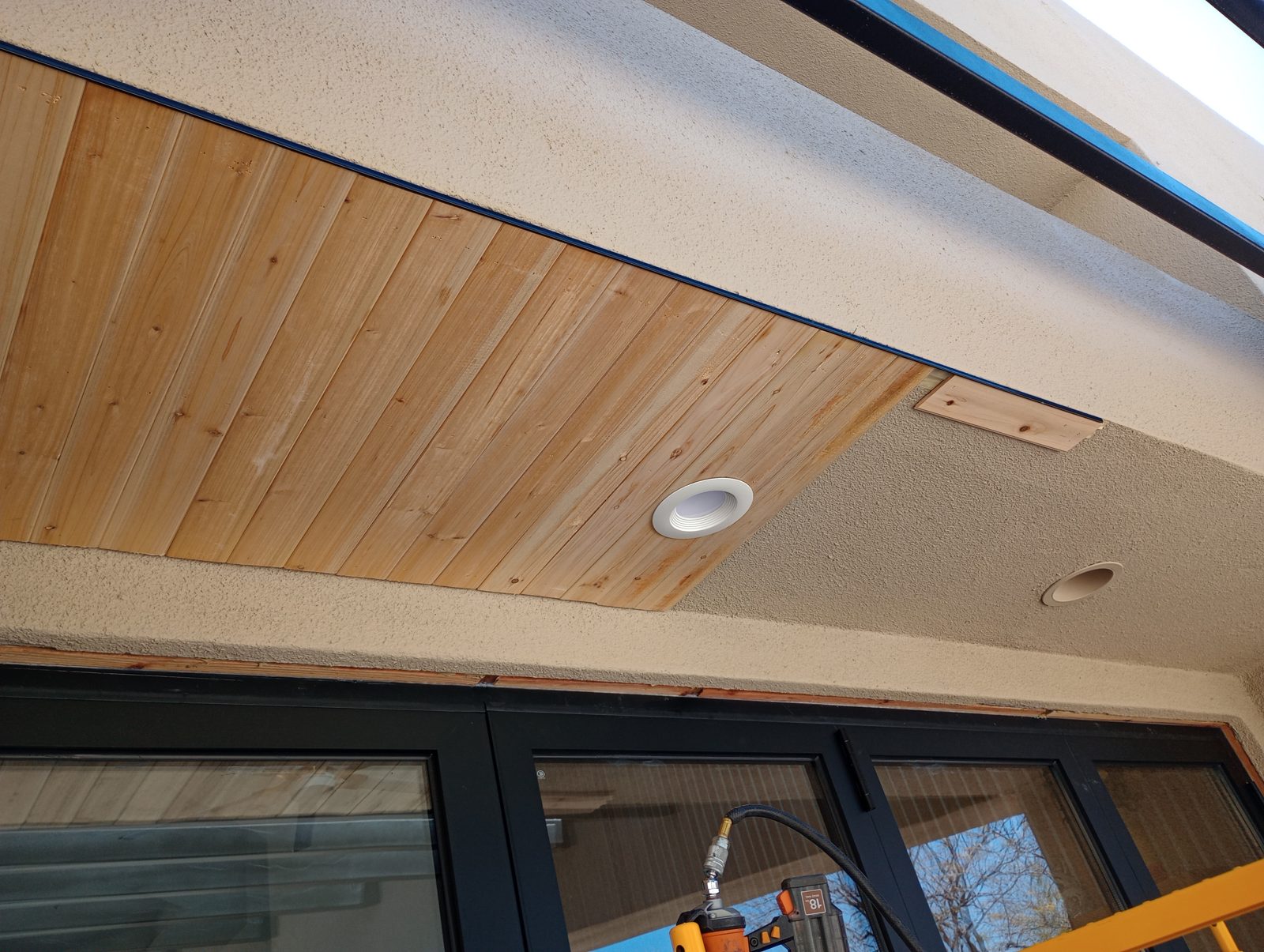 Detail of dark-frame patio door against wood ceiling